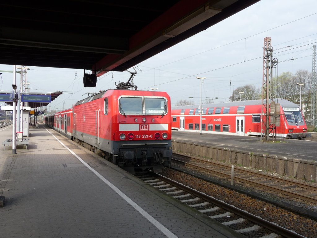 143 259 steht am 09.04.2010 in Wuppertal-Oberbarmen mit ihrer S-Bahn in Richtung M�nchengladbach bereit. Rechts ist eine DOSTO-Garnitur als RE4 nach Aachen zum Stehen gekommen. S8 -> M�nchengladbach Hauptbahnhof