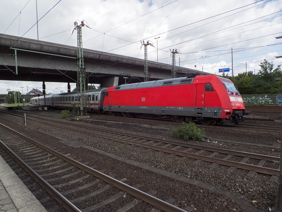 101 096 verlässt am 11.08.14 mit IC 2327 nach Passau den Bahnhof Hamburg-Harburg. Der IC 2327 legt in rund dreizehneinhalb Stunden eine wahre Weltreise hin: Von Fehmarn-Burg auf der gleichnamigen Insel geht es über Bremen, Dortmund, Wuppertal, die Rheinstrecke, den Spessart und Nürnberg nach Passau. Es versteht sich dabei, dass ein Zug mit diesem Laufweg nur saisoniert unterwegs ist.