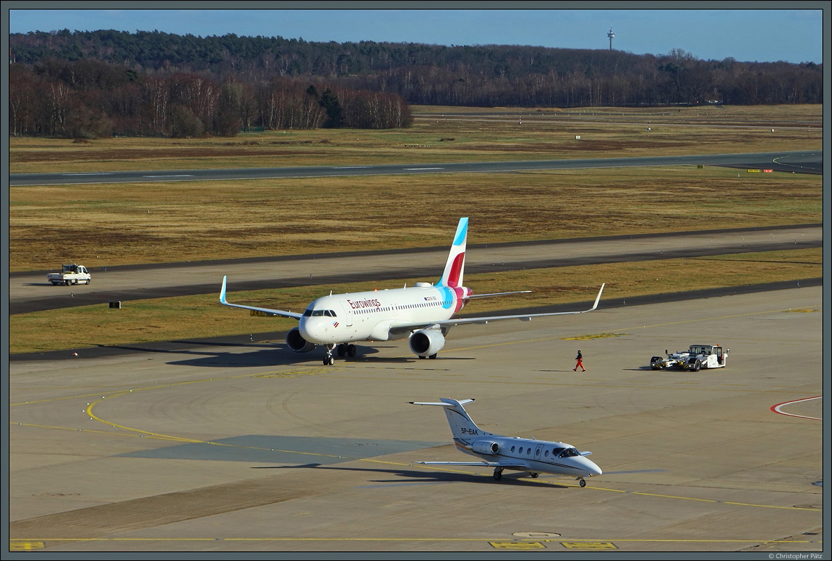 Auf dem Vorfeld des Flughafens Köln/Bonn begegnen sich am 23.02.2022 der A320-200 OE-IQC der Eurowings Europe und die Hawker 400XP SP-EAK der Smart Jet.