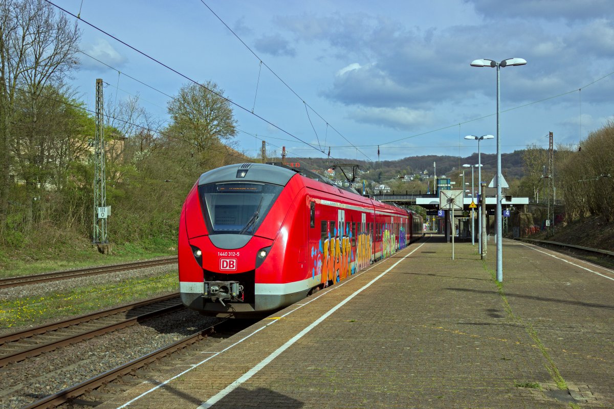 Mit einem gro�fl�chigen Graffito ist 1440 312 verziert, der hier als S8 gerade in Richtung M�nchengladbach ausf�hrt.