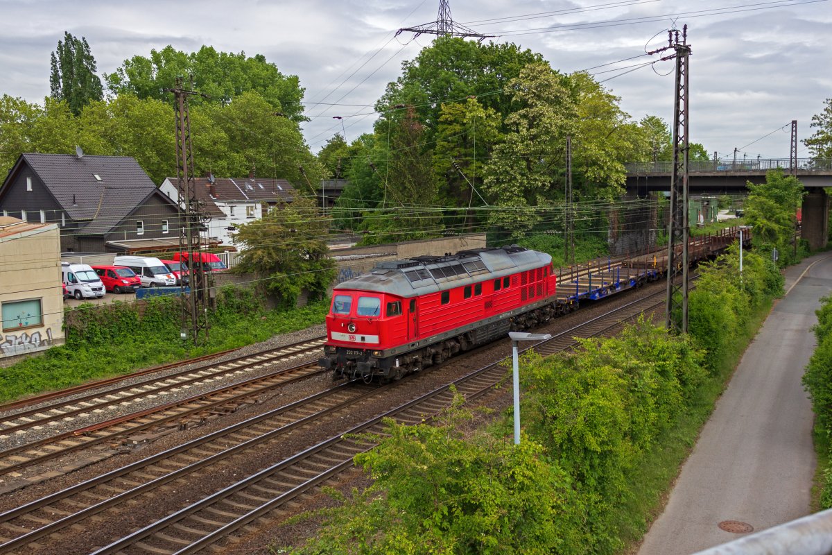 Mit einem Leerzug aus Flachwagen ist 232 117 in Oberhausen unterwegs.