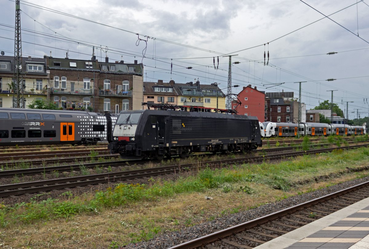 W�hrend im Hintergrund eine Reservegarnitur des RRX auf einen Einsatz wartet, rollt am 08.07.2021 die ES64F4-087 solo durch K�ln-West.
