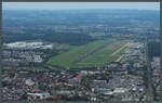 Der Flughafen Friedrichshafen entstand 1915 als Landeplatz für die hier gefertigten Zeppeline. Noch heute landen diese regelmäßig im linken Teil des Flughafengeländes. Rechts der Piste 06/24 befinden sich das Terminal und das Dorniermuseum. (Friedrichshafen, 05.10.2023)