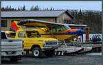 Zusammen mit einem farblich passenden Pickup steht die private PA-18-150 Super Cub C-FLXG am Ufer der Back Bay von Yellowknife.